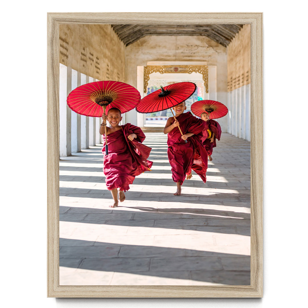 Three monks in red robes are walking down a hallway, each holding a red umbrella.