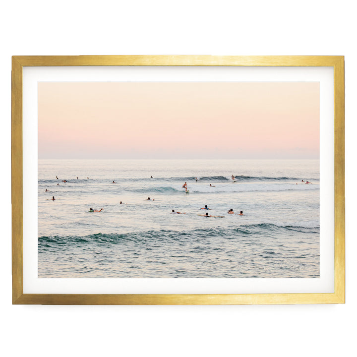 a group of people enjoying themselves in the ocean, with some of them riding waves on surfboards.