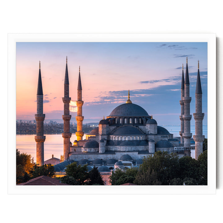 the Blue Mosque, also known as the Sultan Ahmed Mosque, in Istanbul, Turkey, with its distinctive domes and minarets silhouetted against a colorful sunset sky.