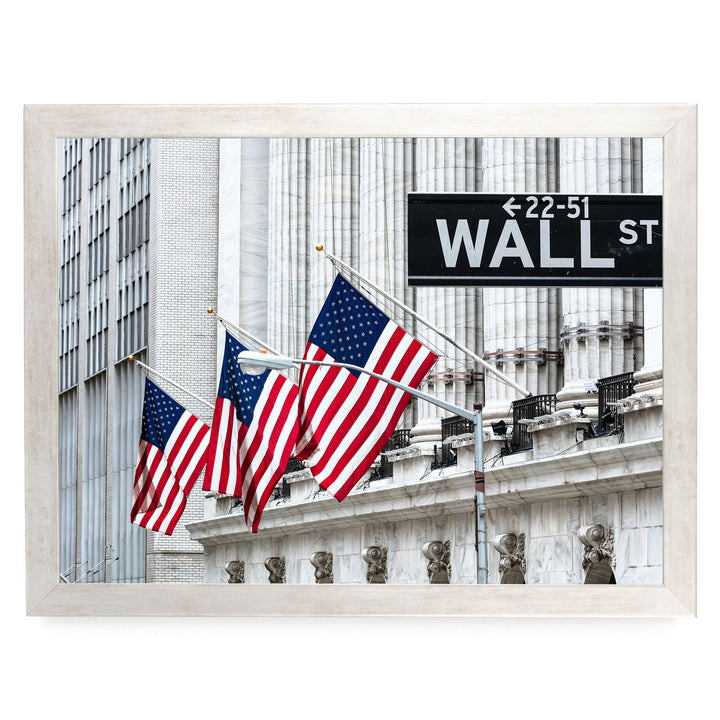 the iconic Wall Street building with three American flags flying in front of it, displaying the sign "WALL ST" indicating the location.