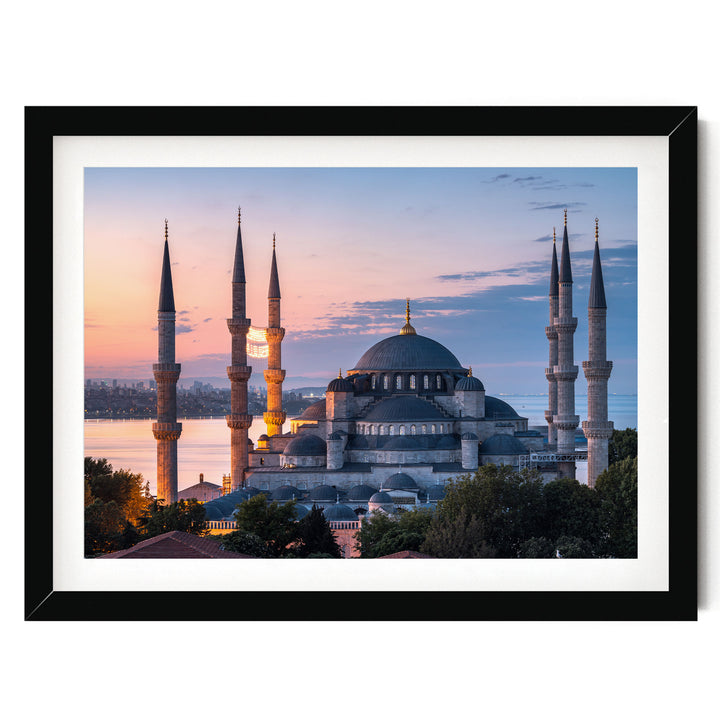 the Blue Mosque, also known as the Sultan Ahmed Mosque, in Istanbul, Turkey, with its distinctive minarets and domes silhouetted against a colorful sunset sky.