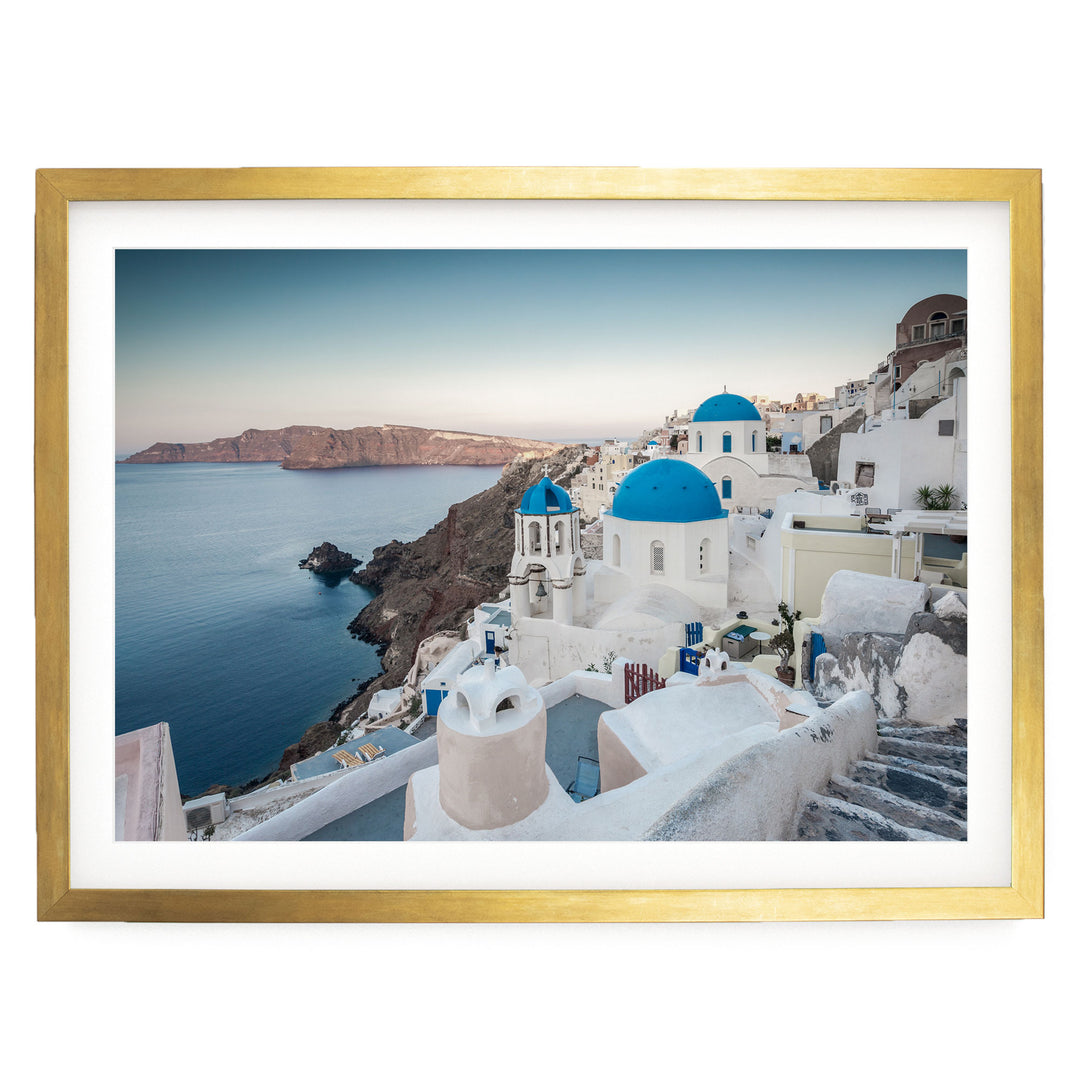 a picturesque coastal town with white buildings and blue domes, overlooking the ocean.
