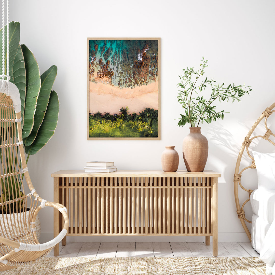 a modern and minimalist living room with a wooden console table, a woven chair, a potted plant, and a framed abstract painting on the wall.