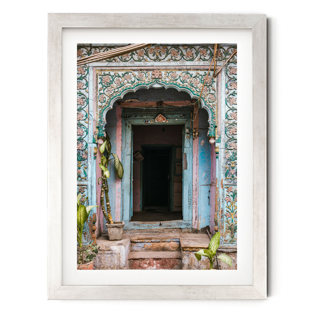 a colorful, ornate doorway with intricate designs and patterns, surrounded by lush greenery and plants.