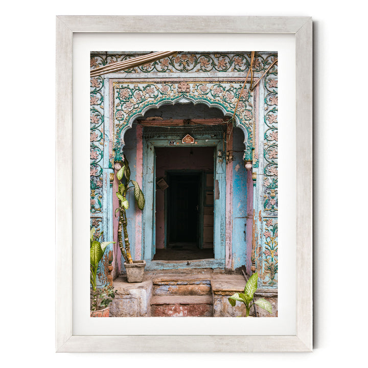 a colorful, ornate doorway with intricate designs and patterns, surrounded by lush greenery and plants.