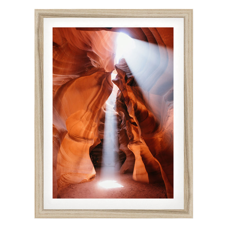 a stunning natural rock formation with a bright light shining through the narrow passage, creating a dramatic and captivating scene.