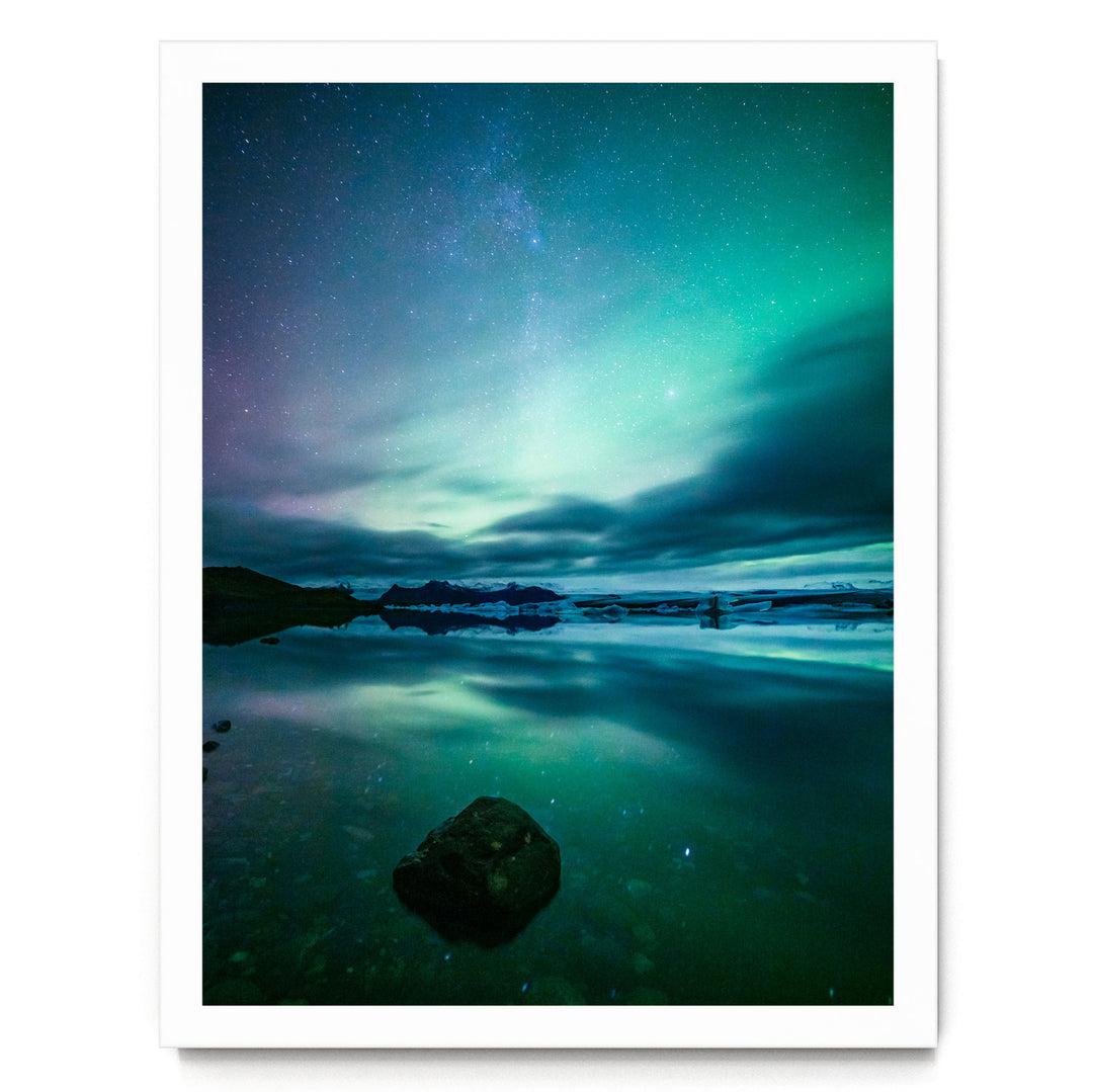 a serene night scene with a starry sky reflected in a calm body of water, creating a beautiful and tranquil atmosphere.