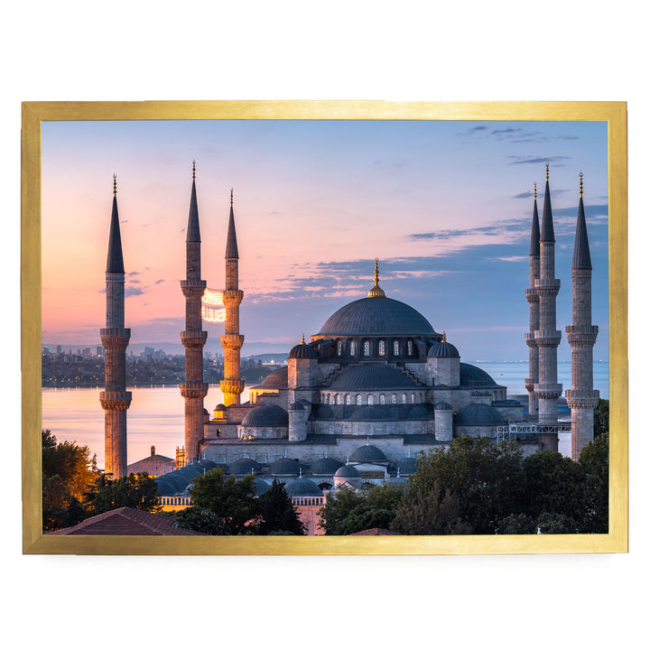 the Blue Mosque, also known as the Sultan Ahmed Mosque, in Istanbul, Turkey, with its distinctive domes and minarets silhouetted against a colorful sunset sky.