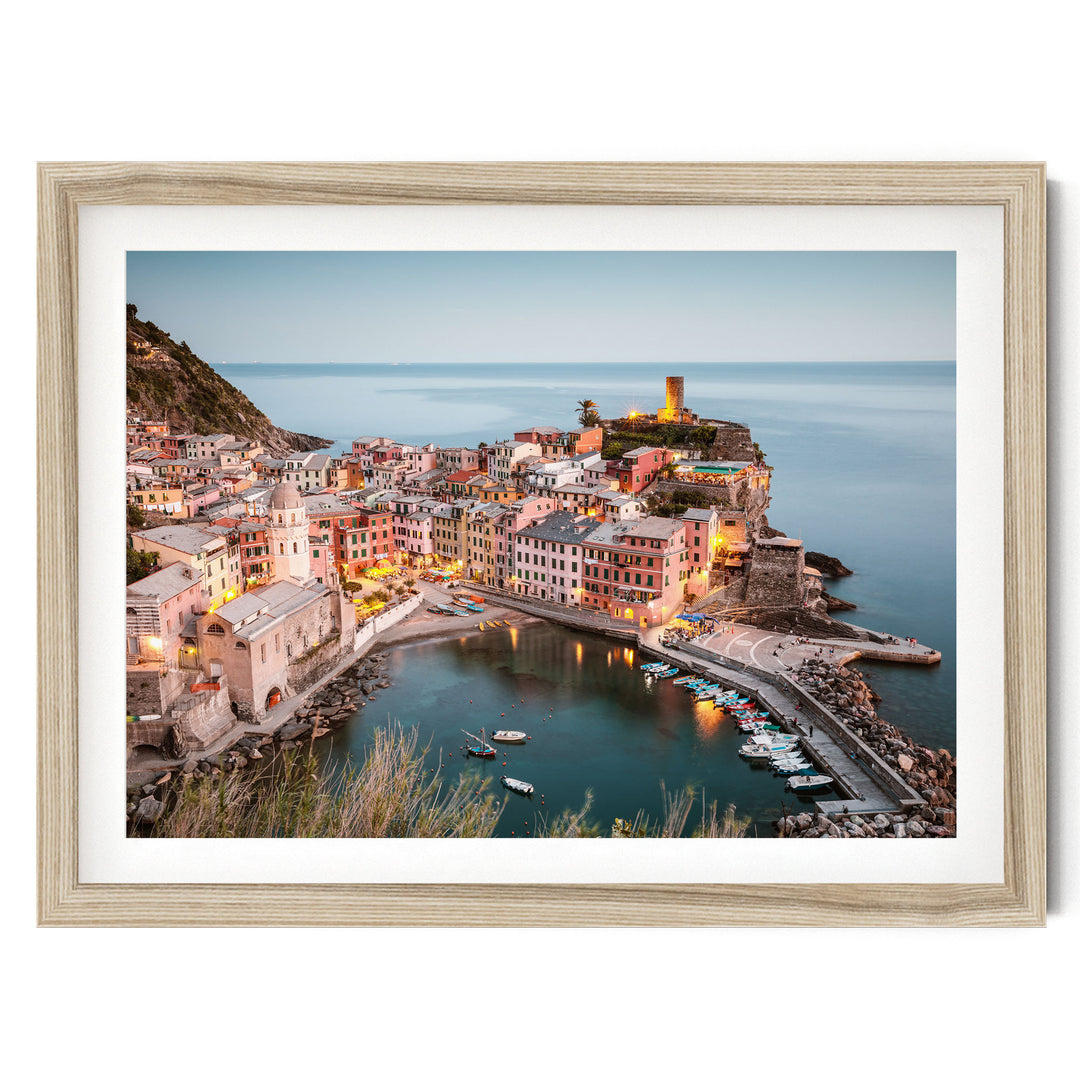 a picturesque coastal town with colorful buildings, a harbor filled with boats, and a lighthouse on a cliff overlooking the water.