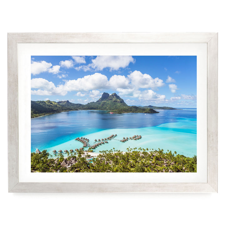a picturesque tropical island with crystal clear turquoise waters, lush green vegetation, and a mountainous backdrop.