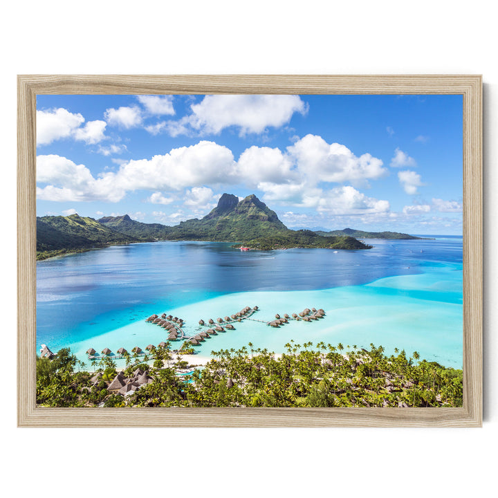 a tropical island with a large mountain in the background, surrounded by turquoise waters and lush greenery.