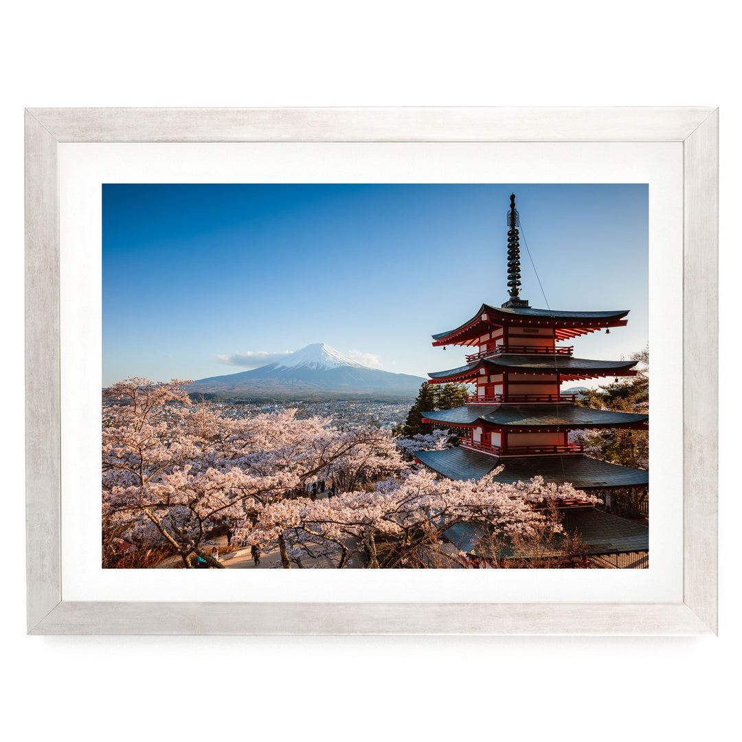 A framed photograph of a traditional Japanese pagoda overlooking a mountainous landscape with cherry blossoms in full bloom.