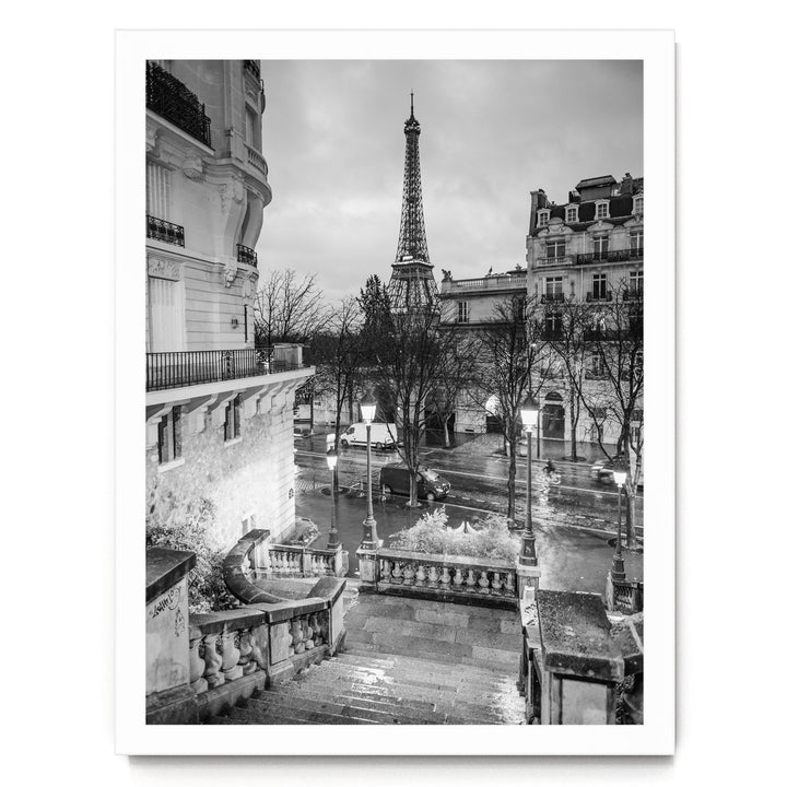 A black and white photograph of the Eiffel Tower in Paris, France, with the surrounding buildings and streets visible.