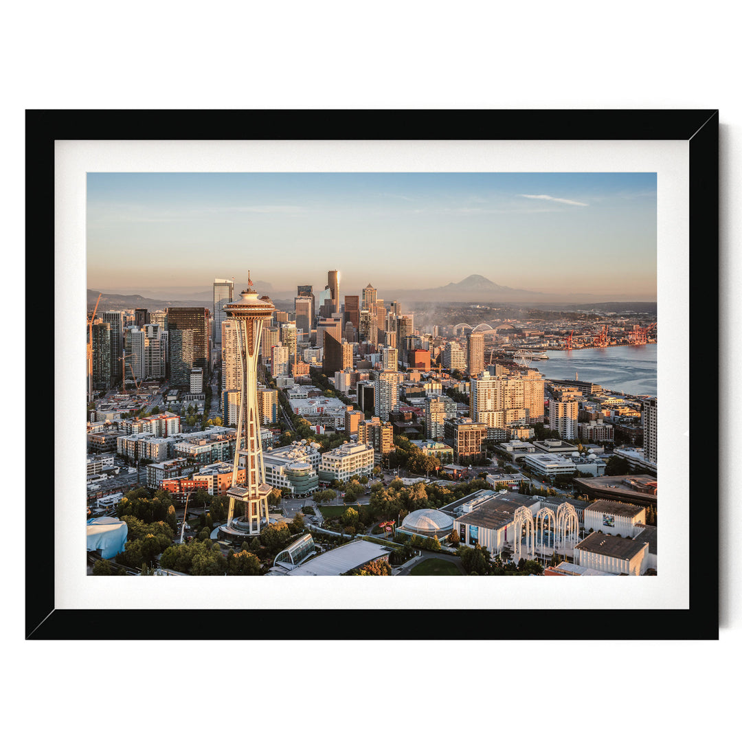 The image is a panoramic view of the Seattle skyline, showcasing the iconic Space Needle and the surrounding cityscape.