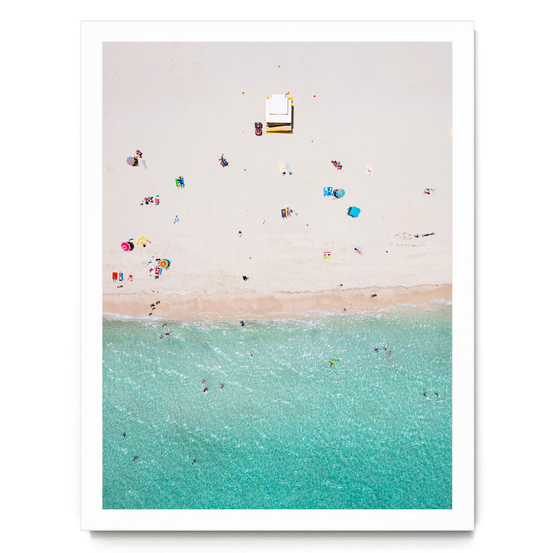 a beach scene with people enjoying the sun and water, featuring a small white structure on the sand.