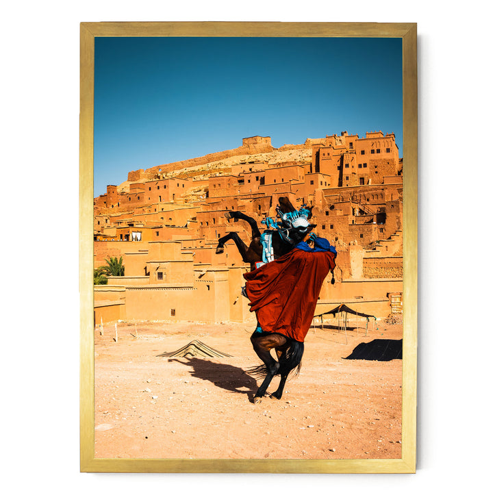 A person riding a horse in a desert-like setting, with a large, multi-story structure in the background.