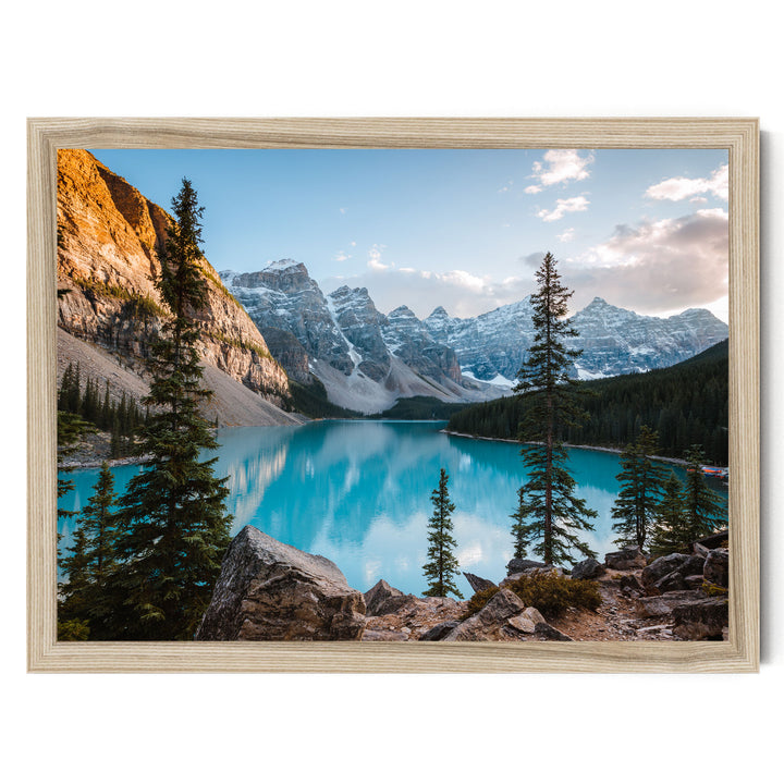 A breathtaking view of a serene mountain lake surrounded by towering peaks and lush forests, with a clear blue sky overhead.