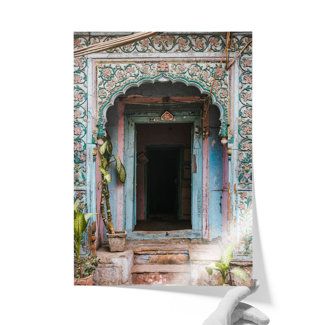 a colorful, ornate doorway with intricate carvings and decorations, surrounded by lush greenery and potted plants.