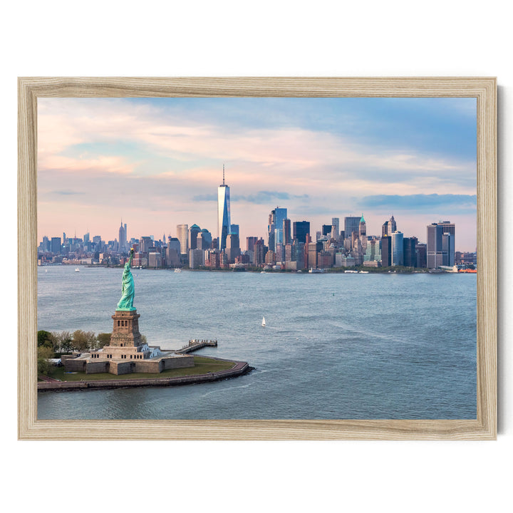 the Statue of Liberty on a small island in the foreground, with the New York City skyline in the background.
