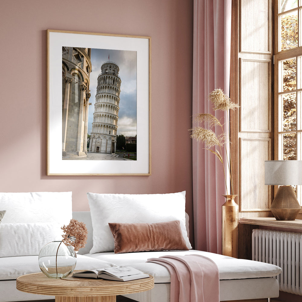 Framed Leaning Tower of Pisa print displayed above a sofa in a pink living room