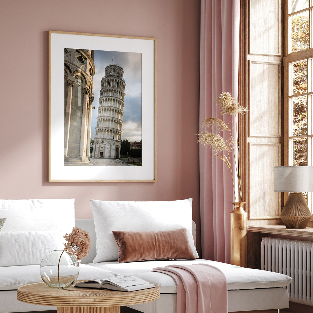 Framed Leaning Tower of Pisa print displayed above a sofa in a pink living room