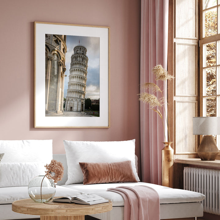 Framed Leaning Tower of Pisa print displayed above a sofa in a pink living room