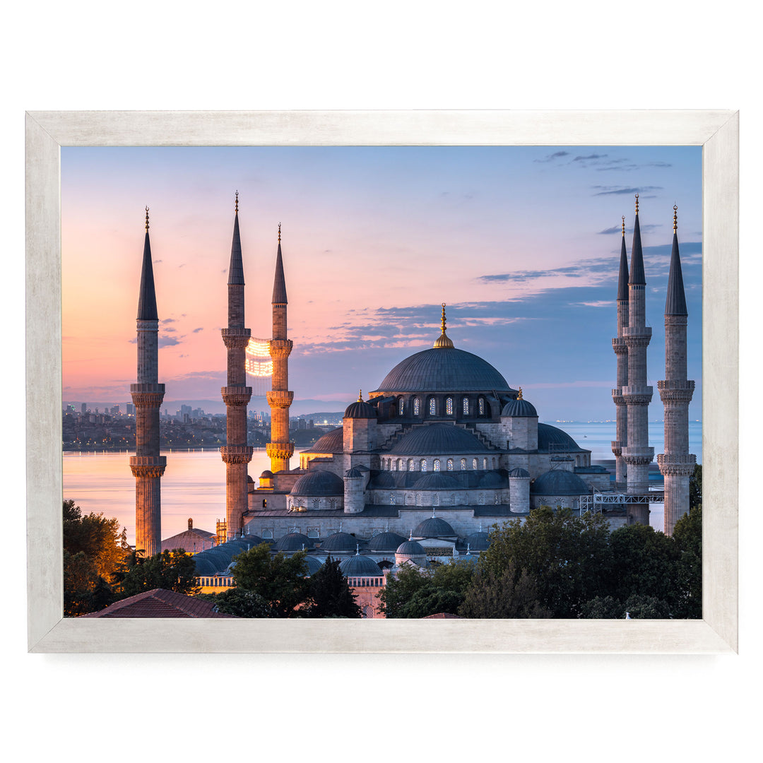the Blue Mosque, also known as the Sultan Ahmed Mosque, in Istanbul, Turkey, with its distinctive domes and minarets silhouetted against a colorful sunset sky.