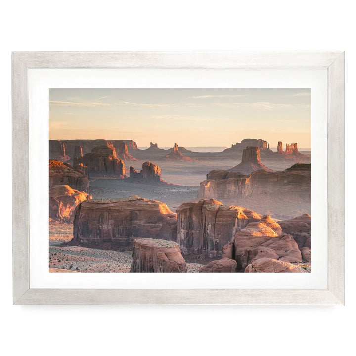 a breathtaking view of the Grand Canyon, with its vast, rugged landscape stretching out under a warm, golden sunset. The canyon's towering rock formations and deep crevices create a dramatic and awe-inspiring scene, showcasing the natural beauty of this iconic landmark.