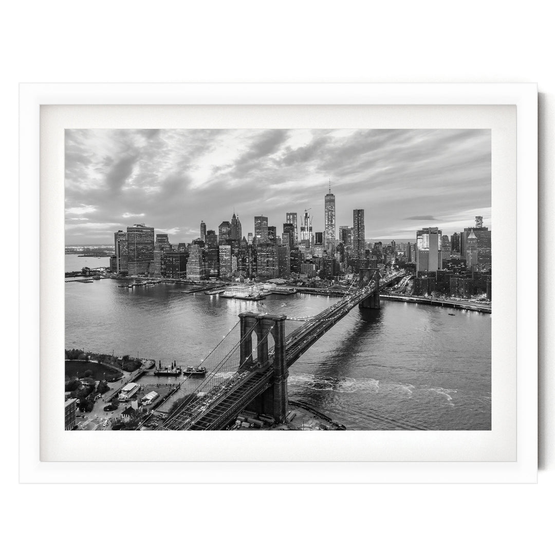 A black and white aerial view of the New York City skyline, showcasing the iconic Brooklyn Bridge and surrounding skyscrapers.