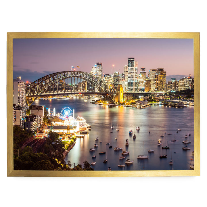 a vibrant cityscape at night, with a large bridge spanning a river and numerous boats dotting the water. The city skyline is illuminated by the lights of the buildings, creating a stunning and captivating scene.