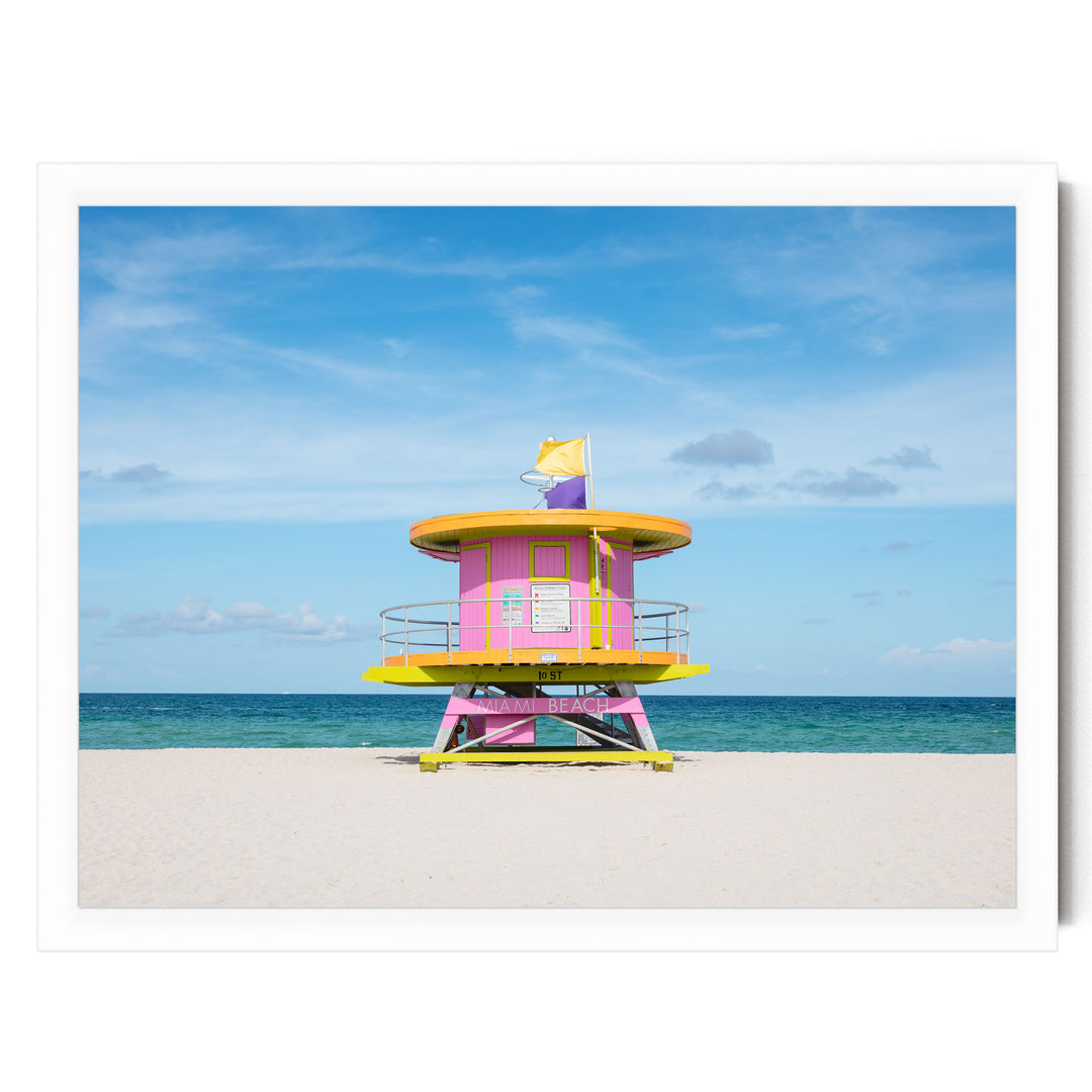 A brightly colored lifeguard tower stands on a sandy beach, overlooking the ocean.