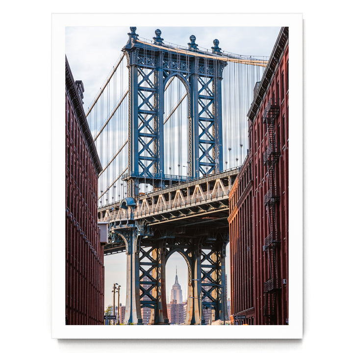 a large suspension bridge with multiple towers and cables, spanning across a river or valley. The bridge is surrounded by red brick buildings, creating a striking contrast between the modern structure and the traditional architecture. The scene is captured from a low angle, emphasizing the height and grandeur of the bridge.