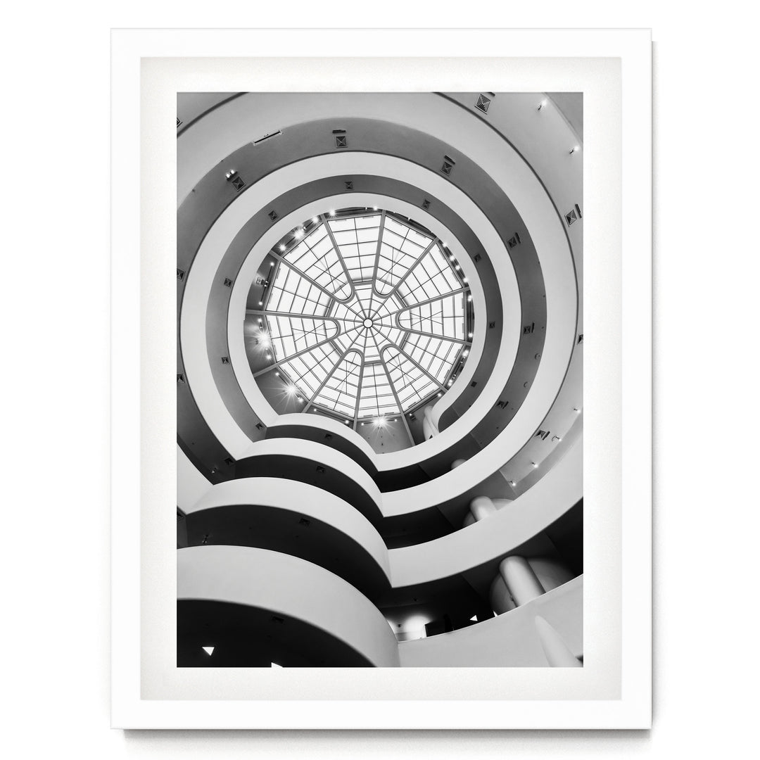 A black and white photograph of a spiral-patterned building with a large glass dome at the center, creating a striking visual effect.