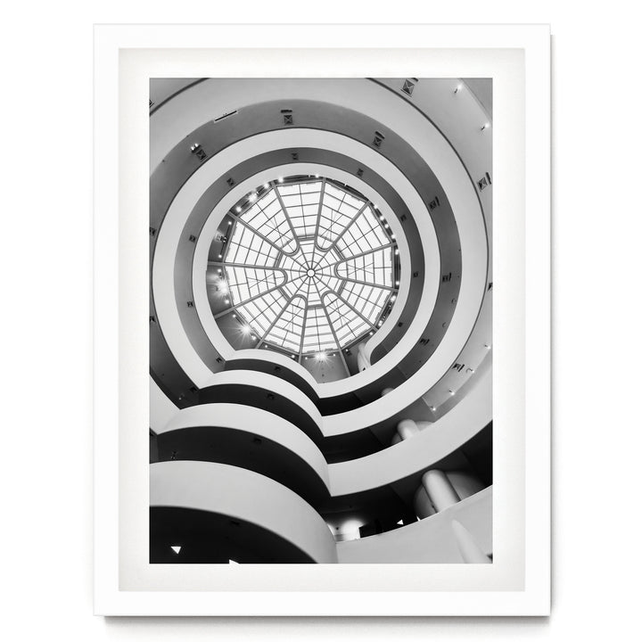 A black and white photograph of a spiral-patterned building with a large glass dome at the center, creating a striking visual effect.