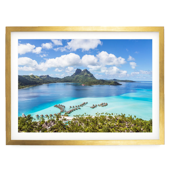 a picturesque tropical island with crystal clear turquoise waters, lush green vegetation, and a mountainous backdrop.