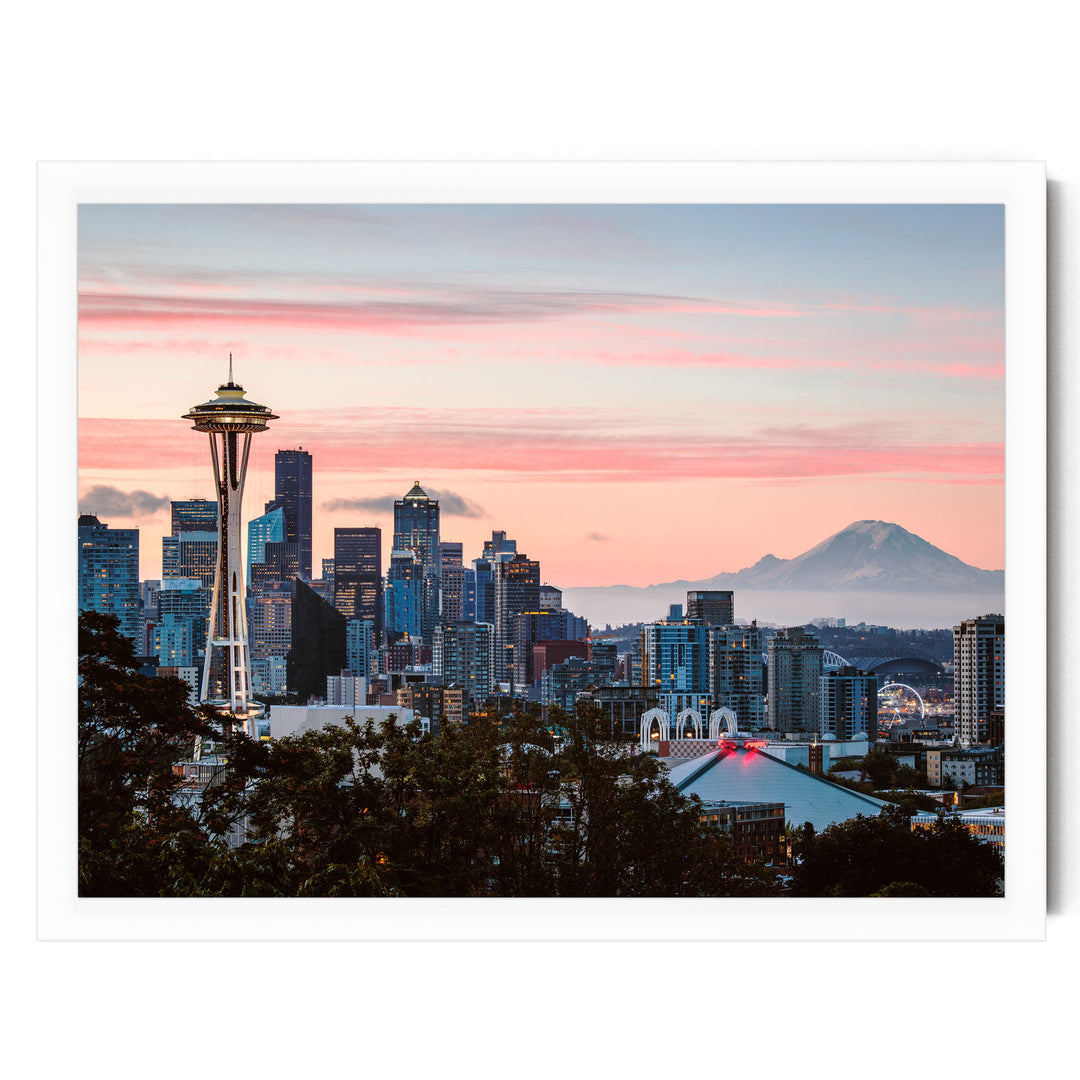 a city skyline at sunset, with the Space Needle and other high-rise buildings silhouetted against a vibrant pink and orange sky.