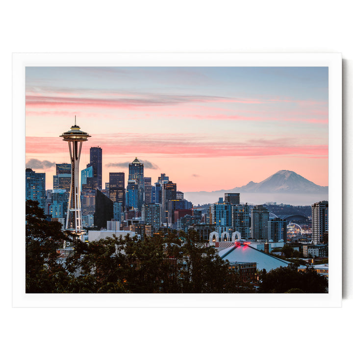 a city skyline at sunset, with the Space Needle and other high-rise buildings silhouetted against a vibrant pink and orange sky.