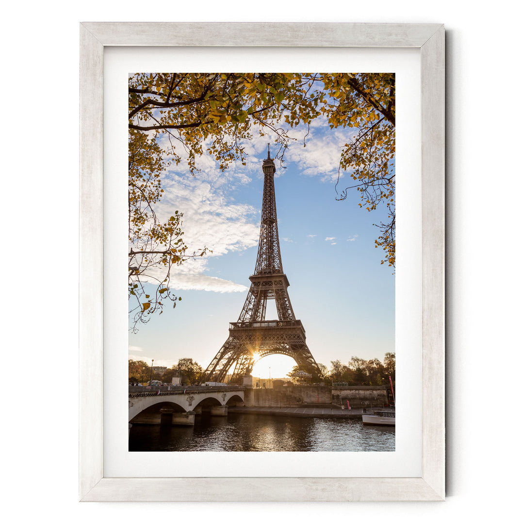 the Eiffel Tower, a famous landmark in Paris, France, with a bridge and trees in the foreground.