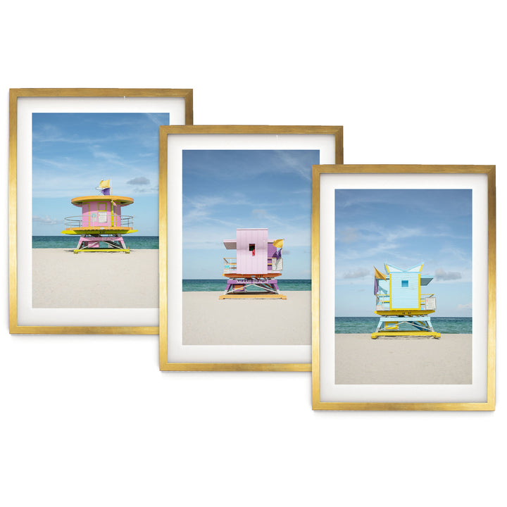 The image is a collage of three framed pictures, each depicting a lifeguard tower on a beach. The lifeguard towers are painted in different colors, including pink, blue, and yellow, and are situated on the sandy beach with the ocean in the background.