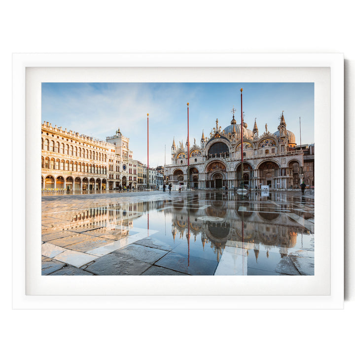 a large, ornate building with arched windows and a domed roof, situated in a square with a fountain in the foreground. The building is reflected in the water, creating a symmetrical and visually striking scene.