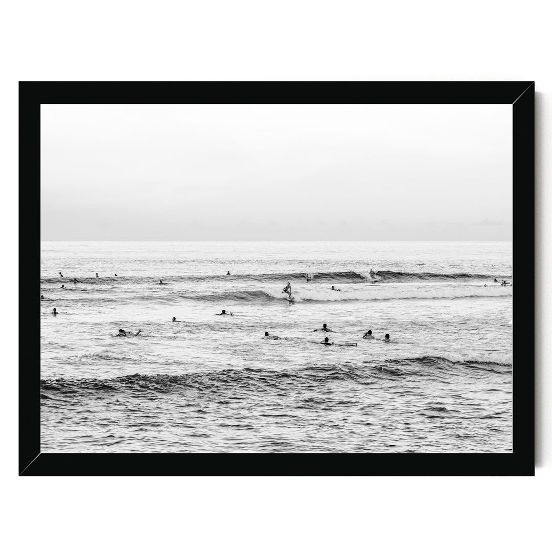 A group of people enjoying themselves in the ocean, with waves crashing around them.