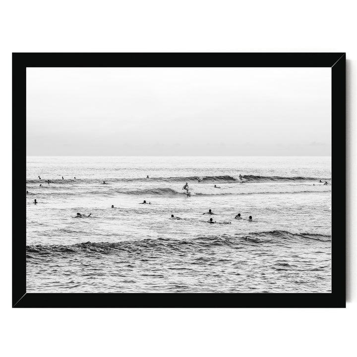 A group of people enjoying themselves in the ocean, with waves crashing around them.