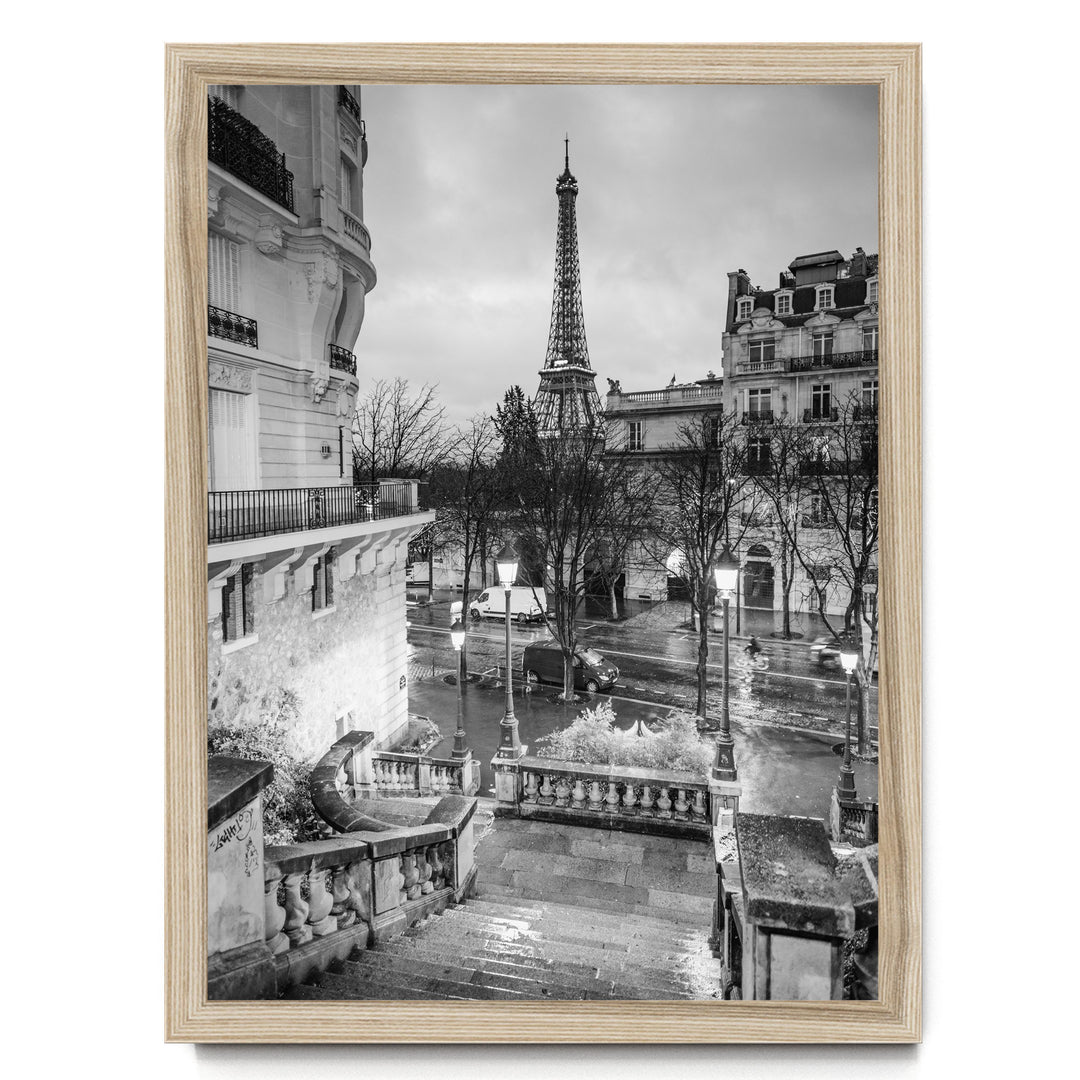 A black and white photograph of the Eiffel Tower in Paris, France, with the surrounding buildings and streets visible.