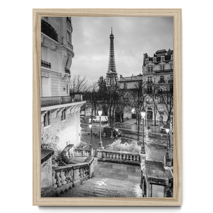 A black and white photograph of the Eiffel Tower in Paris, France, with the surrounding buildings and streets visible.