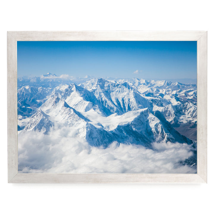 a breathtaking view of snow-capped mountains rising above a vast expanse of clouds, creating a stunning natural landscape.