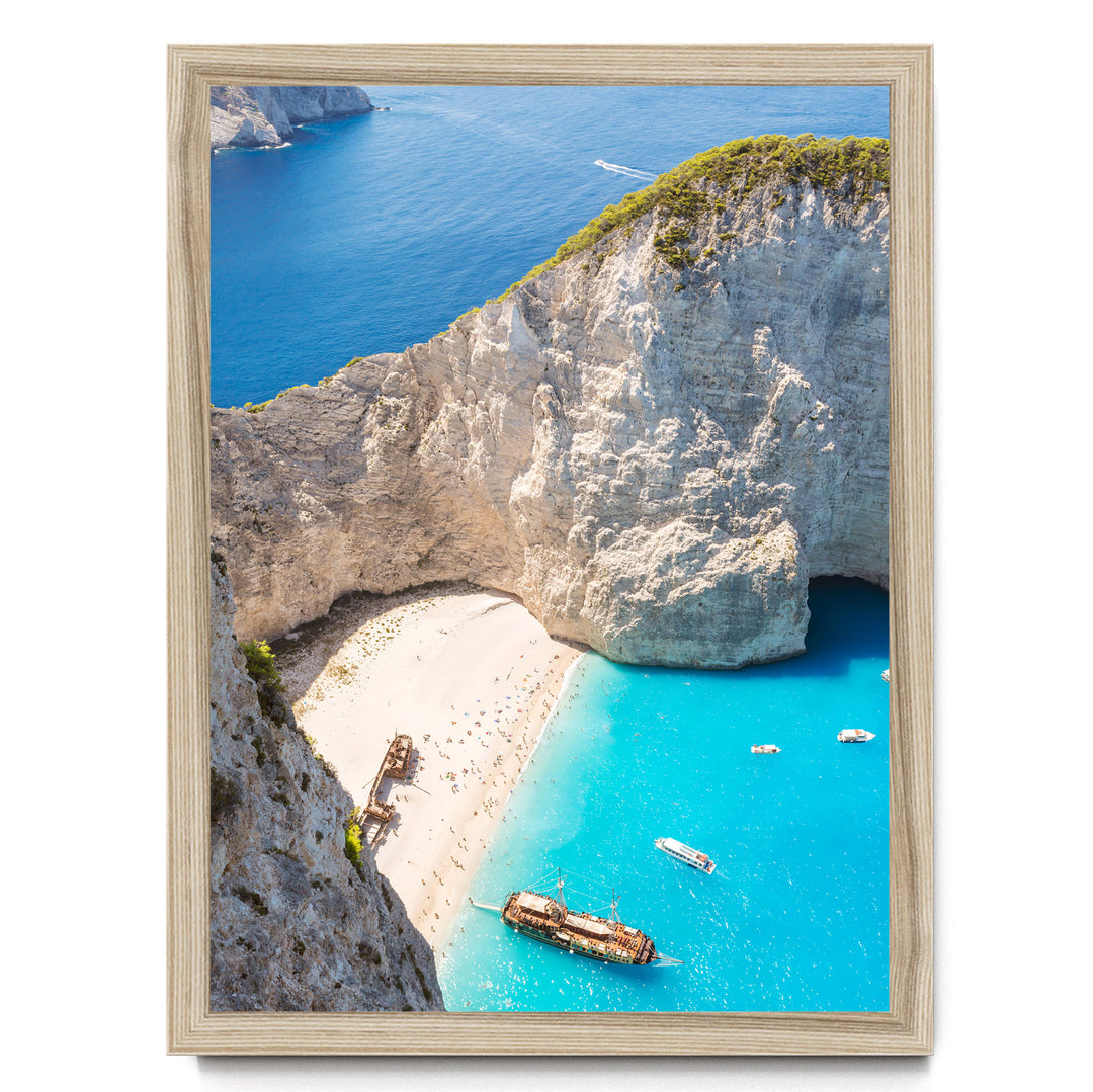 a picturesque coastal scene with a rocky cliff overlooking a beach and turquoise waters. Several boats are visible in the water, adding to the serene atmosphere.