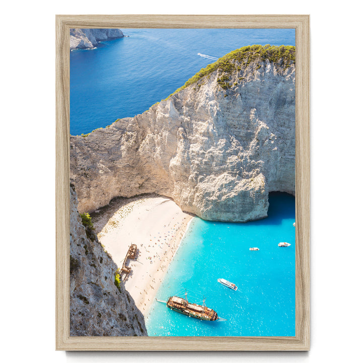 a picturesque coastal scene with a rocky cliff overlooking a beach and turquoise waters. Several boats are visible in the water, adding to the serene atmosphere.