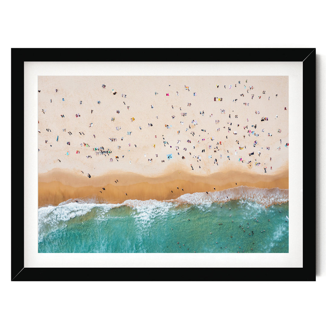 a crowded beach with many people enjoying the sunny day, with waves crashing onto the shore.