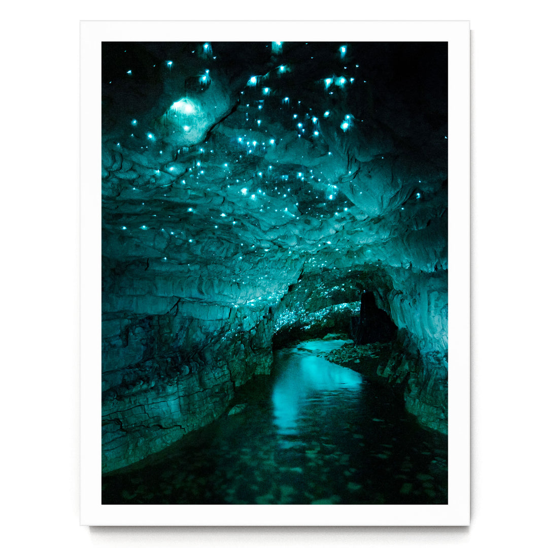 a cave with a stream of water flowing through it, creating a mesmerizing display of blue and green lights.