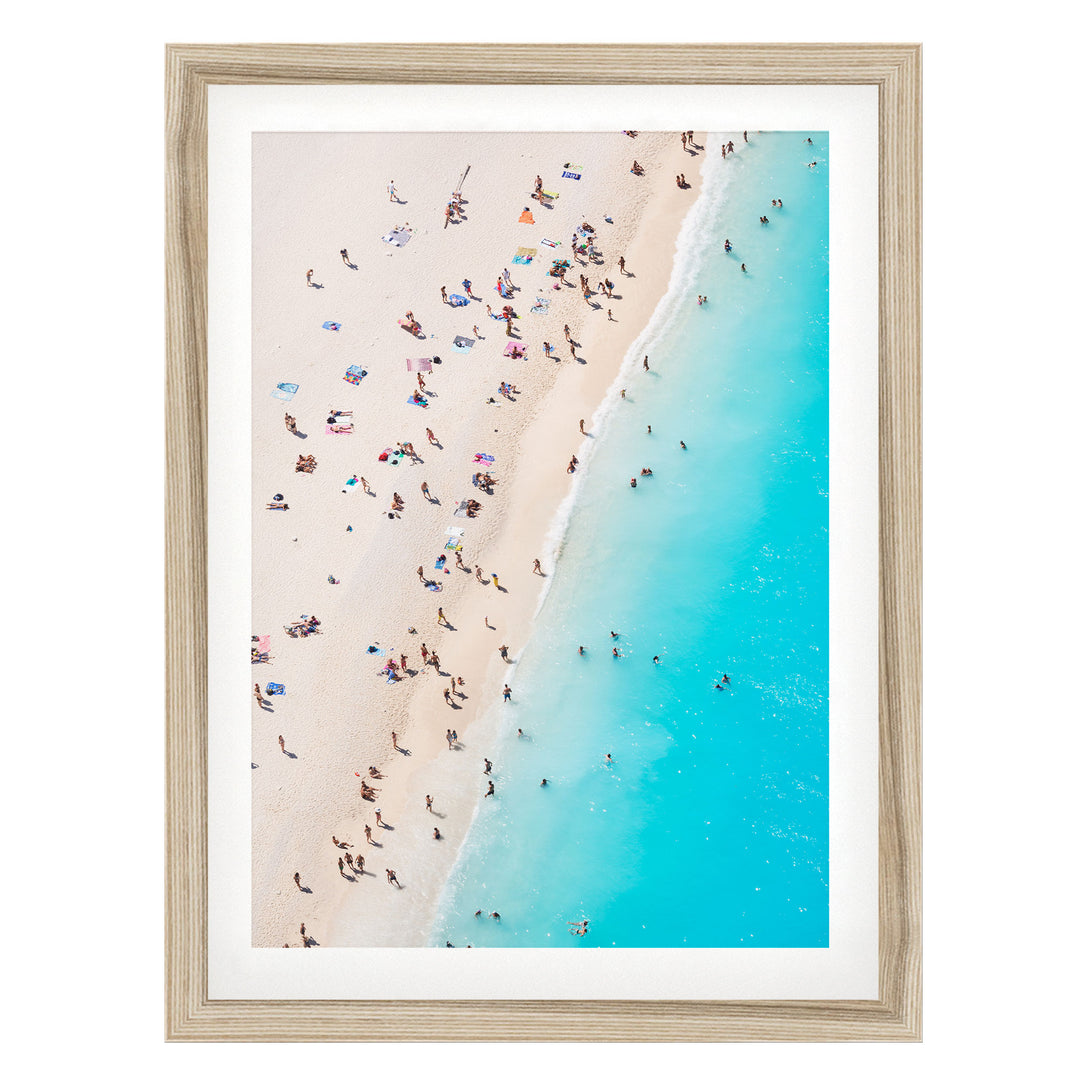 a crowded beach with people enjoying the sun and sand, with the ocean visible in the background.